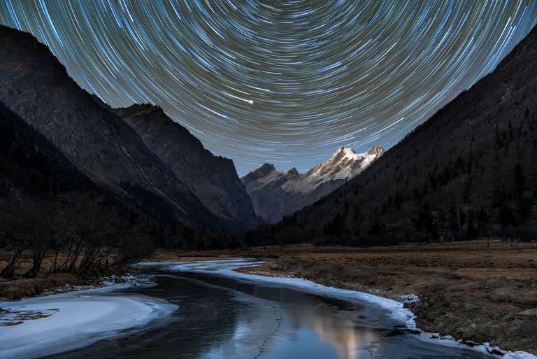 一条河和山的天空中有很多星星