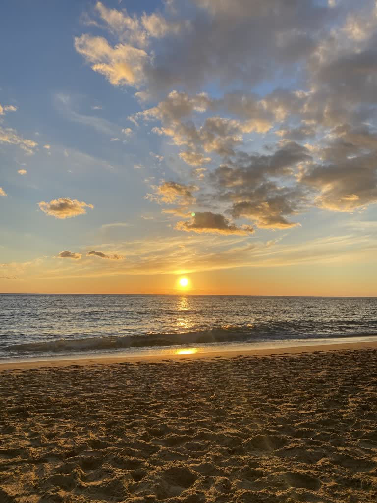 太阳落在沙滩上的海洋上