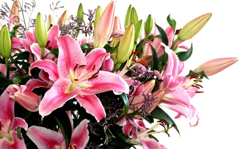 有一个花瓶,里面装满了粉红色的百合和其他鲜花