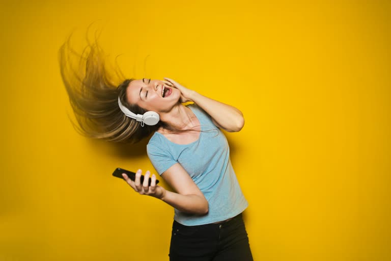 有一个女人正在用手机听音乐