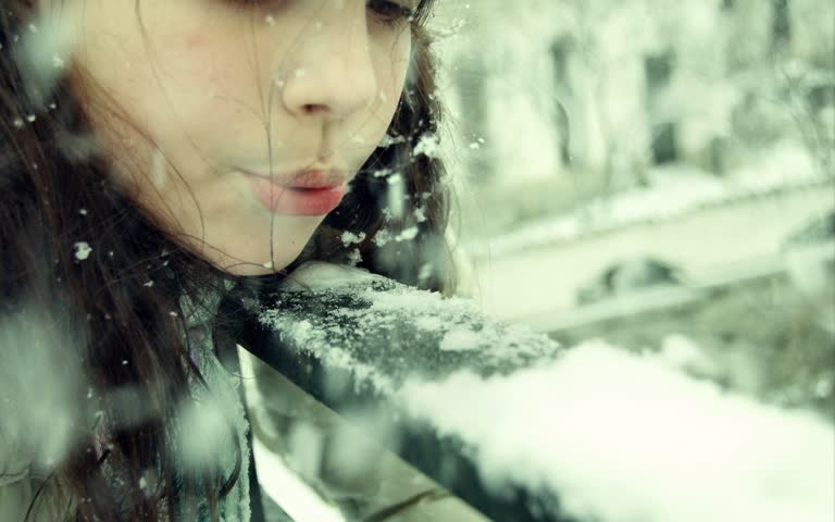 有一个女人在雪地里从窗户向外看