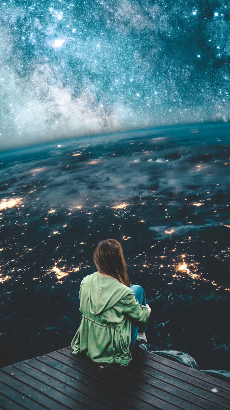 有一个女人坐在码头上看夜空