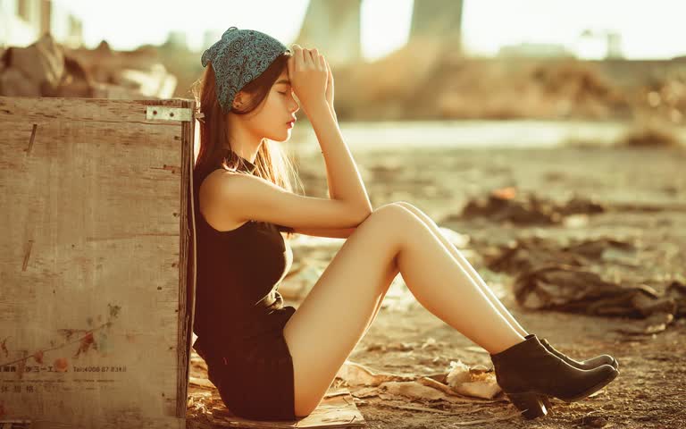 一个木箱旁边坐在地上的女人