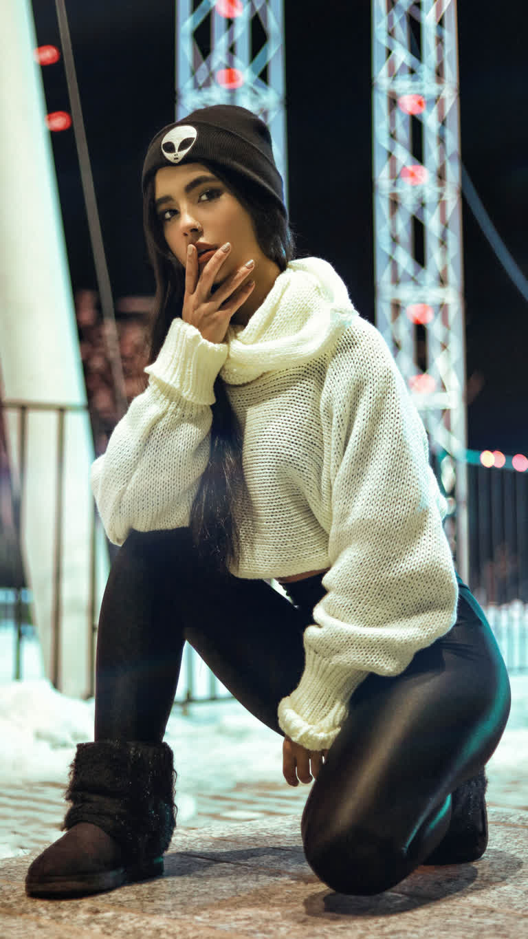 地上坐着一个身穿白色毛衣和黑色裤子的女子